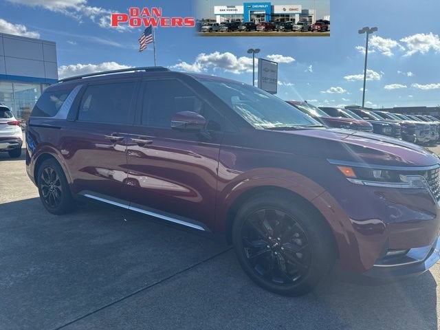 2024 Kia Carnival SX in Red — front three-quarter view